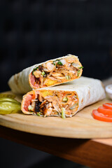 Fresh delicious pork shawarma in pita bread on a plate