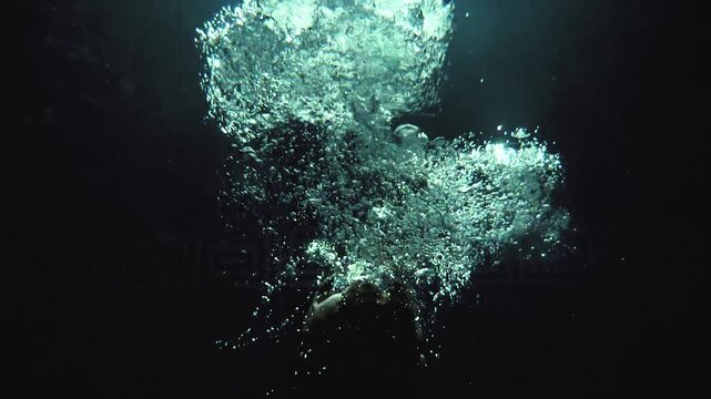 Cinematic Underwater Portrait of Powerful Athlete Releasing Air Bubbles