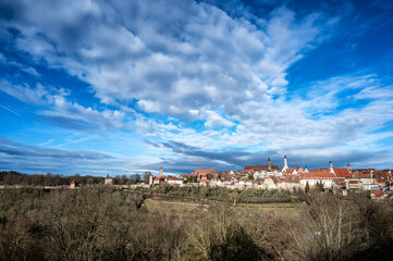 Cityscape view of Rothenburg ob der Tauber, Germany with leafless trees and a dramatic sky