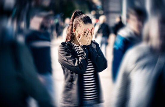 Anxiety, panic attack or fear in street. Stress or schizophrenia. Depressed woman with mental health disorder or agoraphobia. Afraid of crowd of people.
