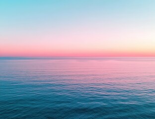 Obraz premium A serene ocean view at sunset, showcasing a gradient of soft pink and blue hues across the sky and water.
