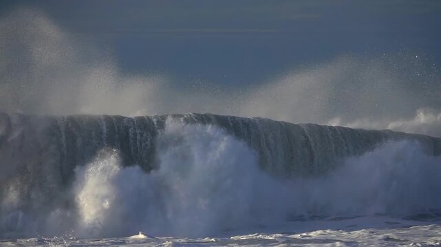 big wave sea spray foam, blue sky.
