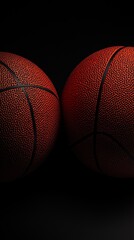 Two Basketballs Close Together on a Dark Background in a Sports Setting