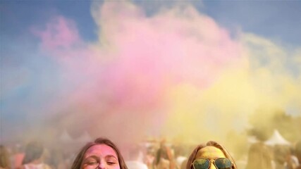 Happy Young Women Dancing at a Color Holi Festival