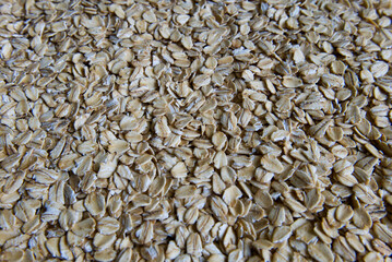 Scattered oat flakes background. Healthy breakfast ingredient. Dry raw oats for oatmeal, granola, or muesli.