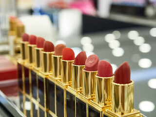 A close-up, collection of high-end lipsticks arranged in a diagonal line, showcasing a variety of rich colors