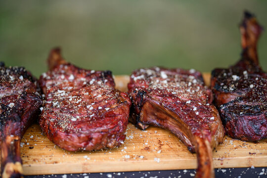 Close-up of four Tomahawk steaks on a wooden chopping board