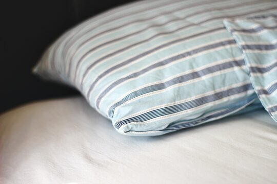 Close-up of a blue striped pillow and duvet on a bed