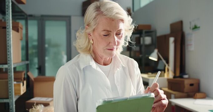 Mature woman, tablet and dropshipping at startup, writing and notes for inventory management at warehouse. Person, entrepreneur and tech with app, stock or report for supply chain at small business