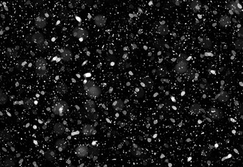 Close-up of delicate white snowfall against a deep black background, creating a speckled winter texture ideal for moody branding, festive designs, and versatile backdrops.