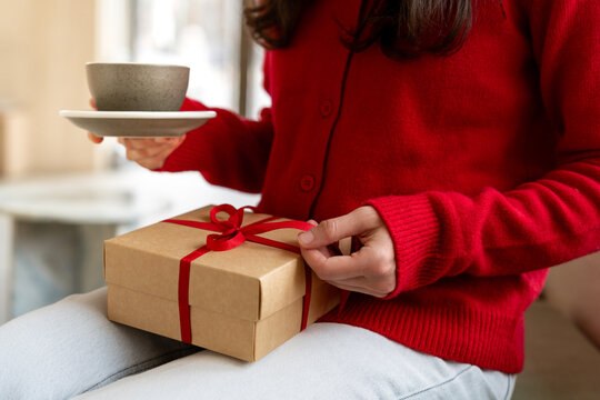 Woman enjoying coffee and holding present during holidays