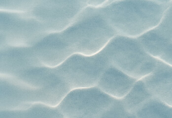 Macro close up of blue-tinted sand revealing wind-sculpted ridge patterns and delicate granular texture across a calm coastal surface, capturing serene natural artistry and light