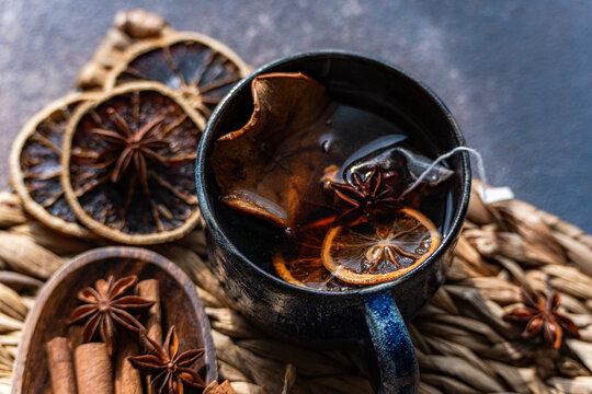 Close-up of a cup of Mulled tea with assorted spices on a rustic table mat