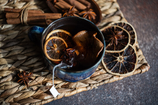 Close-up of a cup of Mulled tea with assorted spices on a rustic table mat