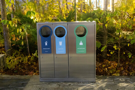 Modern glossy metal trash can. Waste sorting. Green concept.