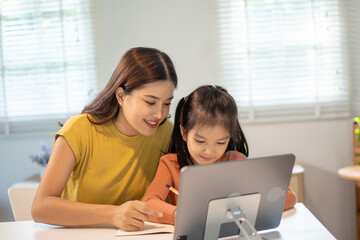 Fototapeta premium Lovely mom and little young daughter spending time together in their living room.