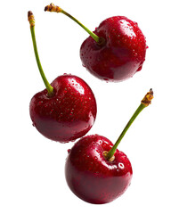 Three glistening cherries, vibrant red, in mid-air