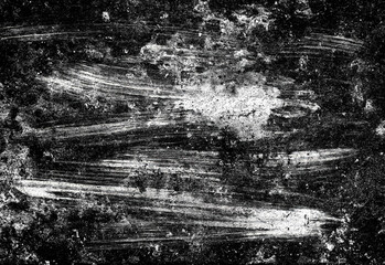 Close up of a gritty black and white textured surface featuring random scratches, smeared brush marks, and distressed patterns that resemble weathered concrete or chalkboard wear