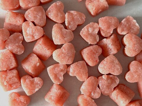 Heart shaped small pink cookie bites close-up background