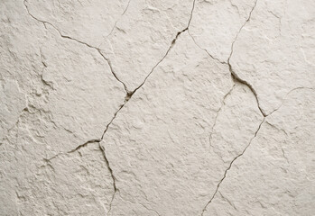 Close up of a light beige cracked dry surface with fissures and rough texture, suitable for background design, texture overlays, architectural visuals, and natural motifs