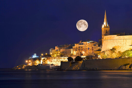 View into land of a Full moon over the old town, Valletta, Malta