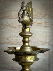 Traditional brass oil lamp (Kuthu Vilakku) in the blurred background, Tamil Nadu tradition