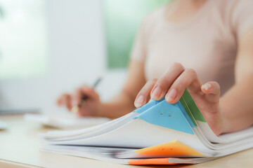 Businesswoman smiling while using laptop and talking on mobile phone at desk in office and at home or coffee shop.