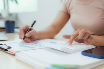 Businesswoman smiling while using laptop and talking on mobile phone at desk in office and at home or coffee shop.