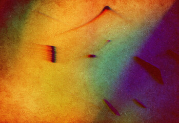 Abstract colorful grain texture blending warm yellow and orange tones with cool blue and purple hues, featuring scattered geometric fragments for vibrant design backgrounds