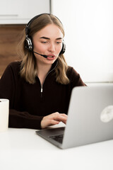 Naklejka premium Concept of Hotline Support Service. Female operator in headset working in call center sitting at the desk