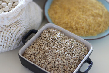 Bowls and bags full of various healthy grains and legumes. Selective focus.