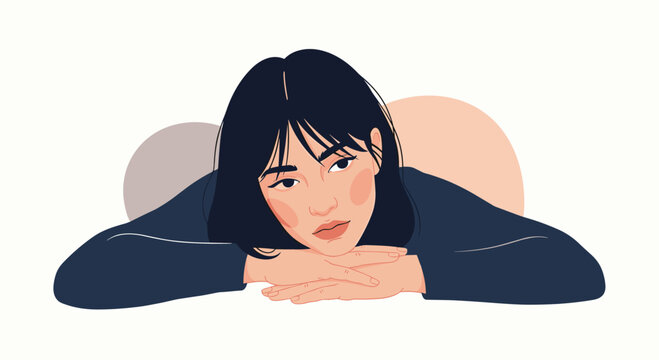 A thoughtful young woman with dark hair rests her chin on her hands.