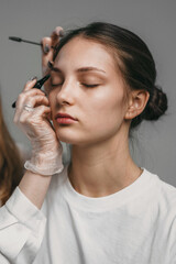 Obraz premium applying mascara smoothly on model, careful mascara application on lightskinned model eyelashes