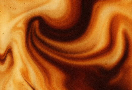 Close-up of swirling caramel and coffee tones in an abstract marbled texture with warm earthy colors, ideal for design backgrounds, wallpapers, textures, and creative layouts.