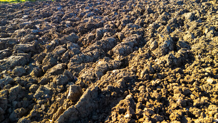 Close-up view of freshly plowed soil with rich texture and natural earthy tones. Ideal for agricultural and environmental themes, showcasing farming practices.