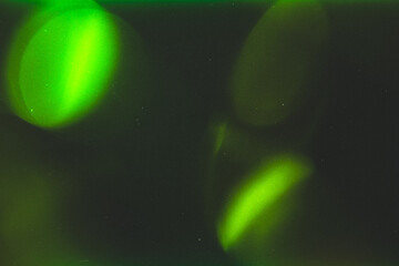 light leak overlay effect with scratch dust and green blur light leaks,retro grain noisy film flare on black background,analog old film burn overlay,abstract background with geeen rays and lens