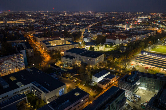 Aerial view of a sprawling cityscape illuminated by the soft glow of streetlights and building windows at night, Berghain, Berlin, Germany.