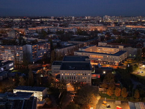 Aerial view of the iconic Berghain standing out amidst the cityscape, its illuminated windows contrasting with the deepening twilight, Berlin, Berlin, Germany.
