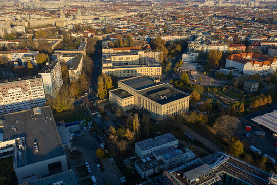 Aerial view of the iconic Berghain nightclub amidst a tapestry of buildings, bathed in the warm glow of the setting sun, Berlin, Berlin, Germany.