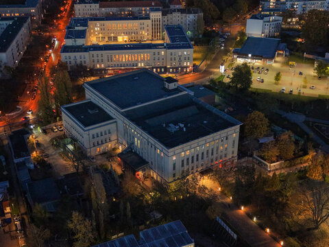 Aerial view of the iconic Berghain nightclub, its stark architecture juxtaposed against the soft glow of streetlights and surrounding buildings, Berlin, Berlin, Germany.