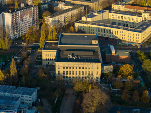 Aerial view of the iconic Berghain nightclub casting long shadows in the fading sunlight, nestled among the autumnal trees, Berlin, Berlin, Germany.