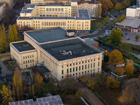 Aerial view of the imposing, box-like Berghain nightclub amidst the autumnal hues of surrounding trees and buildings, Berlin, Berlin, Germany.