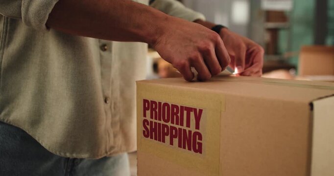Person, hands and box with label, delivery or logistics for distribution or priority order in home. Supplier, distributor or sticker with small business cargo, package or shipping for courier service
