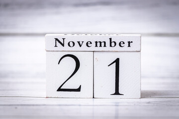 Wooden calendar shows the date November 21, symbolizing the importance of time and organization, suitable for planning or scheduling themes in various contexts.
