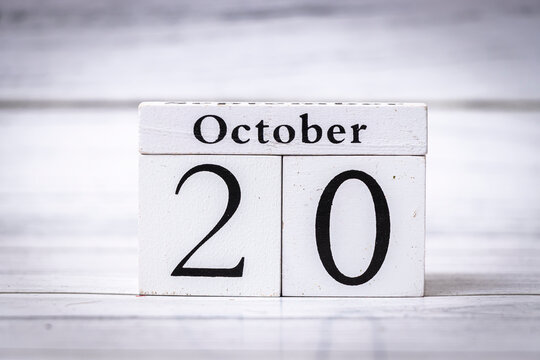 A wooden block calendar displaying the date October 20. This image symbolizes the passing of time and can be used for seasonal themes or events in autumn.