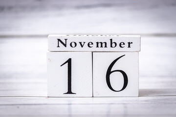 A wooden block calendar displaying the date November 16. This simple yet elegant design captures the essence of time, perfect for seasonal themes and planning.