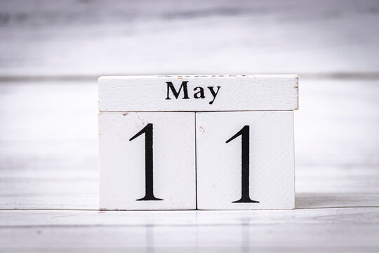 A wooden calendar block displaying the date May 11, featuring bold black digits against a white background. Perfect for organizing events, reminders, or celebrations.