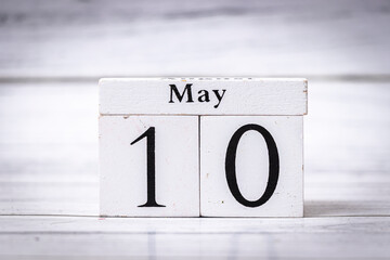 Wooden calendar blocks displaying May 10, emphasizing the significance of this date. Ideal for...