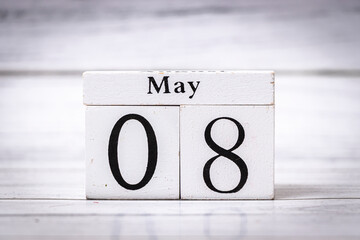 A wooden calendar block displaying the date May 08. The rustic design and neutral colors create a timeless touch suitable for various themes, including organization and celebration.