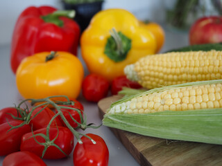 Fresh Corn, Tomatoes and Bell Peppers Arranged on Kitchen Counter in Natural Light